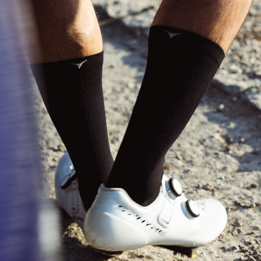 Rider walking wearing black cycling socks and shoes