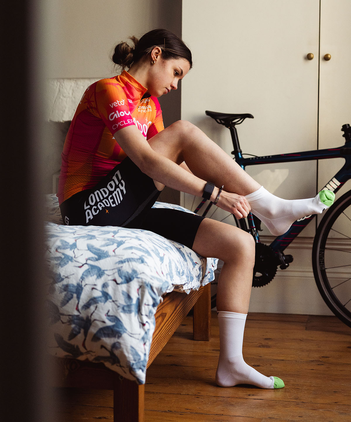 Female cyclist preparing to ride pulling on white cycling socks